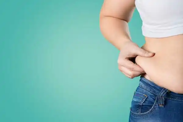 Image of woman pinching her love handles to show weight gain Ascot